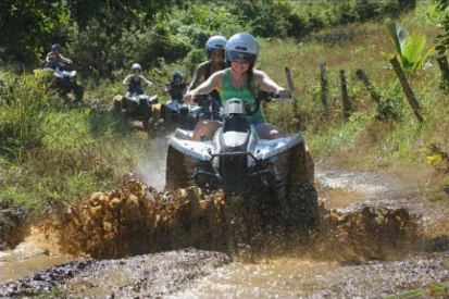 Guest driving an ATV along a muddy Jamaica trail